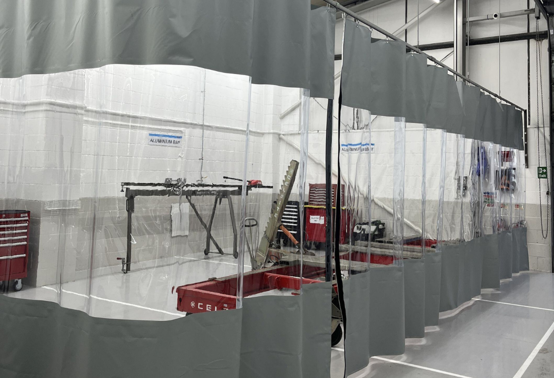 Workshop curtains dividing work areas in a manufacturing facility.