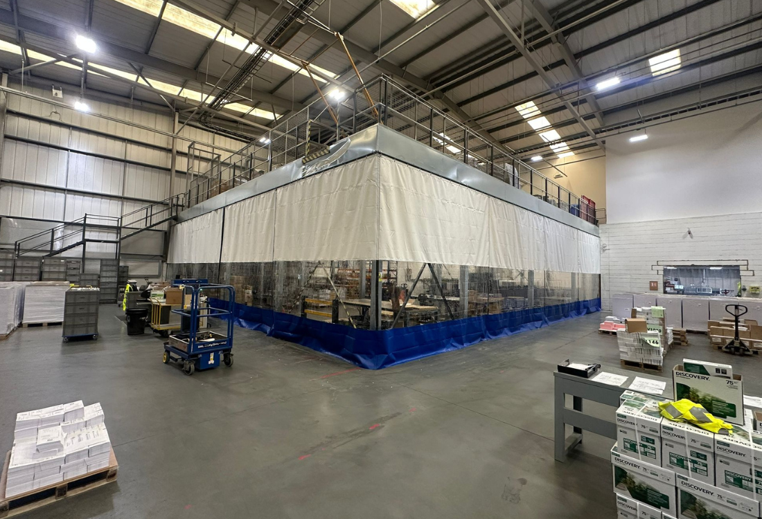 Temporary warehouse partition system enclosing a working production area, professionally installed within an active warehouse environment to enable fast deployment with minimal disruption to daily operations.