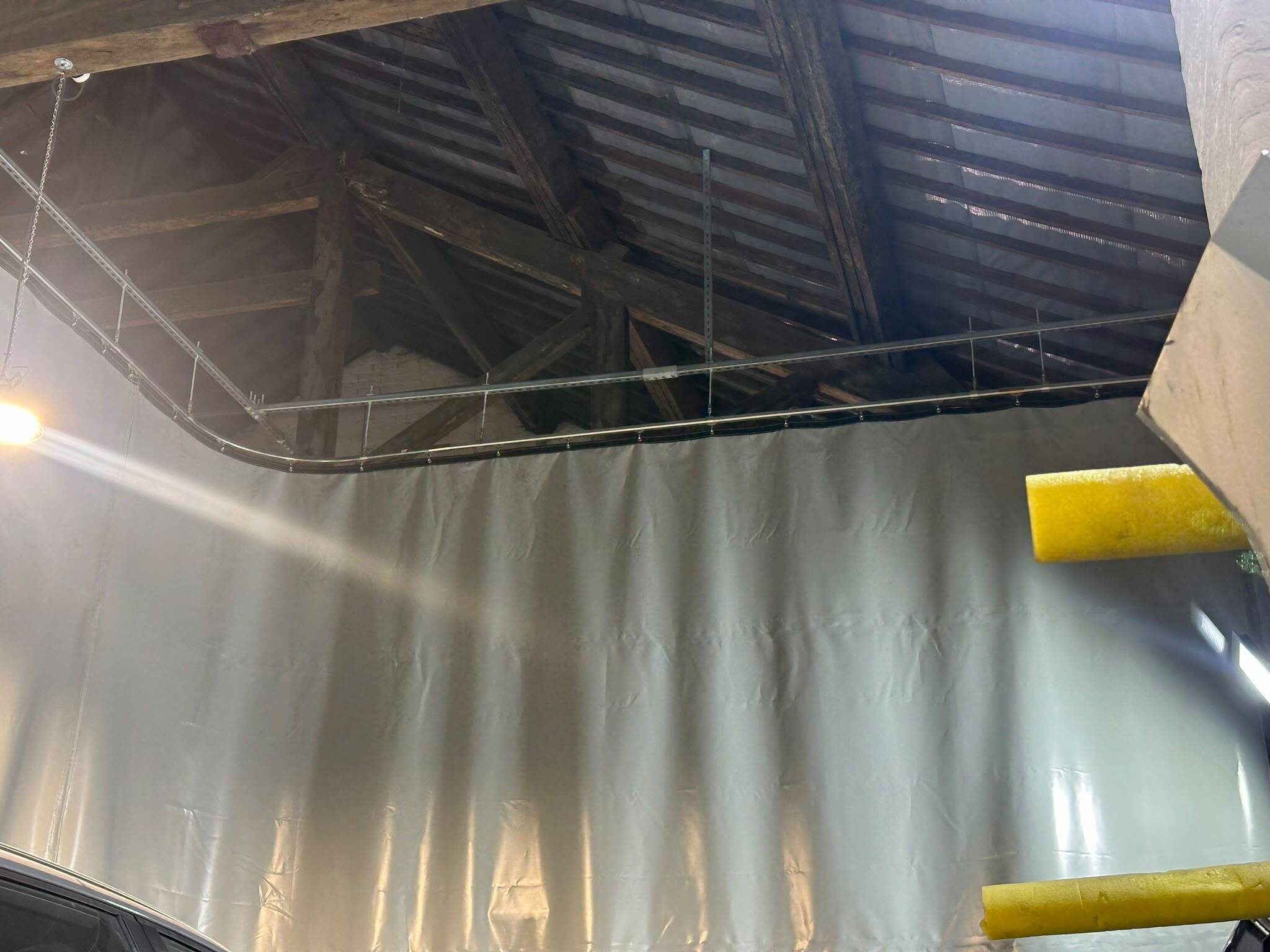 Industrial workshop curtains installed on a ceiling-mounted track to separate working areas.